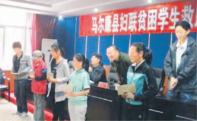 中国侨网高翔(右三)参加四川省阿坝州马尔康市的妇联贫困学生救助金发放仪式。