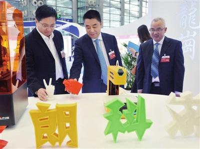 中国侨网高自民(中)、戴斌(左)一行视察龙岗展区。深圳侨报记者 钟致棠 摄