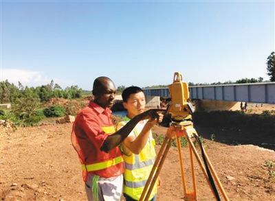 中国侨网图为在非洲的中国工作人员手把手教“新徒弟”测绘。 　　（资料图片）