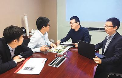 中国侨网张冀鹏（右二）与客户谈如何将古村落改造成现代化民宿的方案。（《人民日报海外版》图片）