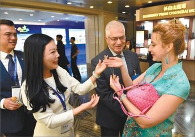 中国侨网中方工作人员向参加活动的外国来宾介绍吉林特产松花石工艺品。 人民视觉