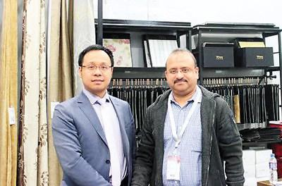 中国侨网杨卫（左）在柯桥春季纺博会上接待海外客商。