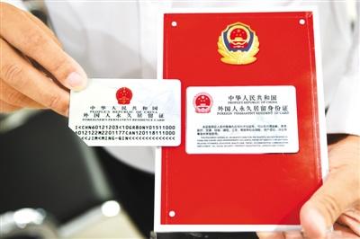 中国侨网2017年6月16日,2017版外国人永久居留身份证启用。图为在北京市公安局出入境管理局中关村外国人服务大厅,一位外籍人士展示取得的2017版外国人永久居留身份证(右)与旧版的区别。 新华社记者 鞠焕宗摄