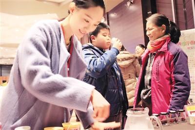 中国侨网为了扩大宣传,刘雅斐常常带着自己的产品出席一些推广活动。图为刘雅斐(左一)为客户示范滋补食品的制作方法。