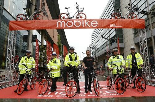 中国侨网资料图片：2017年6月29日，在英国曼彻斯特，几名警察在摩拜单车投放仪式上合影。新华社发