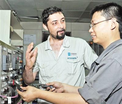 中国侨网劳瑞斯在工作中与同事进行技术交流。 照片由河钢集团唐钢公司提供