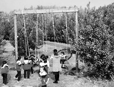 中国侨网孩子们欢天喜地在苹果园玩耍。章林敏摄
