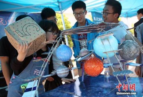中国侨网资料图:4月24日是中国航天日,南京航空航天大学的学生在校园内开展航天嘉年华活动,现场展出了该校自主研制的微小卫星和学生们用废纸箱制作的航天器模型。中新社记者 泱波 摄