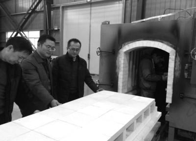 中国侨网张天舒（左三）查看靶材烧结生产环节