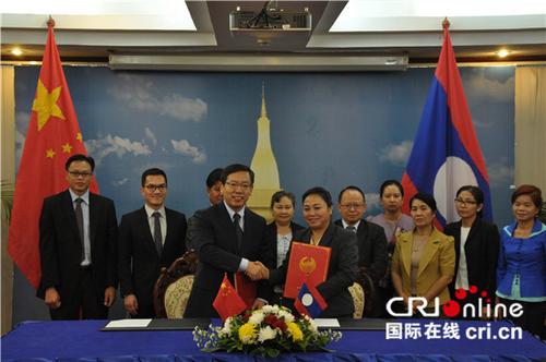 中国侨网中国驻老挝大使王文天（前排左一）和老挝外交部副部长坎葆·因塔万（前排右一）代表双方签约