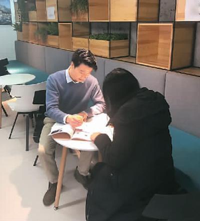 中国侨网图为陈戈(左)与同事探讨关于留学生二手交易中存在问题的调研结果。