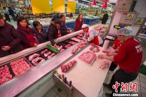 中国侨网资料图：超市员工在为民众分解猪肉。张云 摄