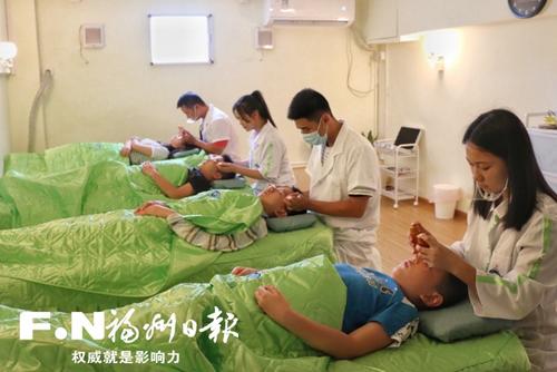 中国侨网邱伟伦(右二)和同事为学生做眼部理疗。(图片来源:福州日报 叶欣童 摄)