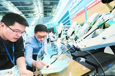 中国侨网昨天（8日），在中关村国家自主创新示范区展示中心，参展人员展示术锐腔镜手术机器人的工作模式。本报记者 饶强摄  
