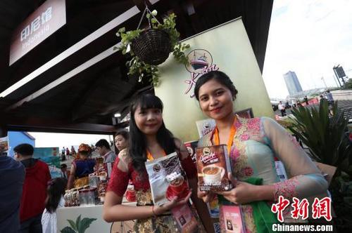 中国侨网身穿传统服饰的印尼女子,为本国展示特色产品。 张亨伟 摄