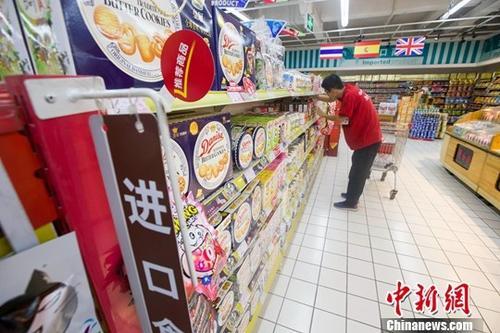 中国侨网资料图：某超市工作人员正在整理商品。中新社记者 张云 摄