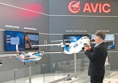 中国侨网在中国航空工业展区，一名参观者正在观摩展出的MA700模型。 （人民日报记者 刘玲玲摄）
