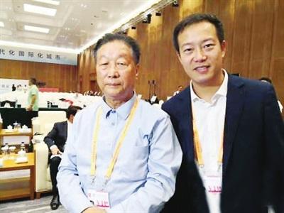 中国侨网2019年9月8日，何钦文（右）与被誉为“世界菌草技术之父”的林占熺教授合影于厦门国际投资贸易洽谈会。（《福建侨报》/受访者供图）