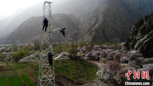 中国侨网电力工人在28米高的35千伏输电铁塔上紧固螺栓。　孙广权　摄