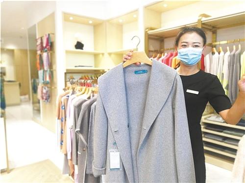 中国侨网图为鄂尔多斯集团销售员展示出口产品。 本报记者 佘 颖 摄