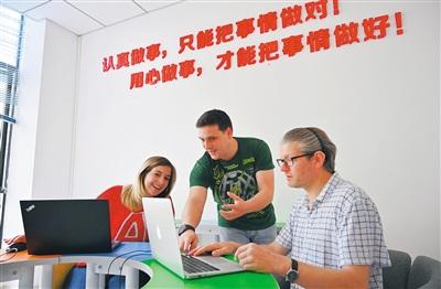 中国侨网海南迈成教育培训有限公司，来自南非的Brandon（中）正在和同事们讨论授课教案。 本报记者 王凯 摄