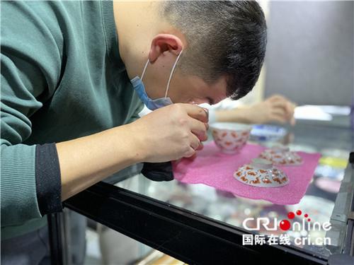 中国侨网民间古玩收藏家在展位前进行鉴定。（摄影 陈毓娟）