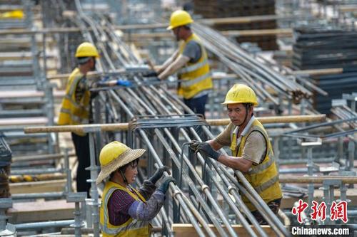 中国侨网图为在海口新海港客运综合枢纽项目工地,工人们正在加紧施工。 骆云飞 摄