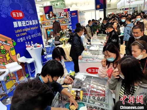 中国侨网图为进口冰淇淋展位前等待品尝的民众。　张道正　摄