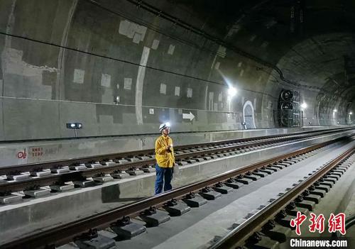 中国侨网图为工人在隧道内检查送电线路。　朱世富　摄