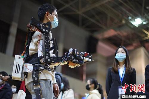 中国侨网参赛大学生演示“无源助力外骨骼机器人”功能。　泱波　摄