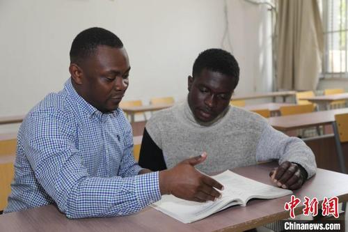 中国侨网来自刚果（金）的留学生荣耀和加纳的卢斌在教室探讨问题。　 杨安　摄