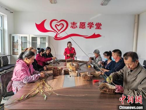 中国侨网图为王玉贤免费教大家柳编技艺。 塔娜 摄