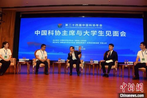 中国侨网全国政协副主席、中国科协主席万钢(中)与大学生代表交流。 中新社记者 孙自法 摄