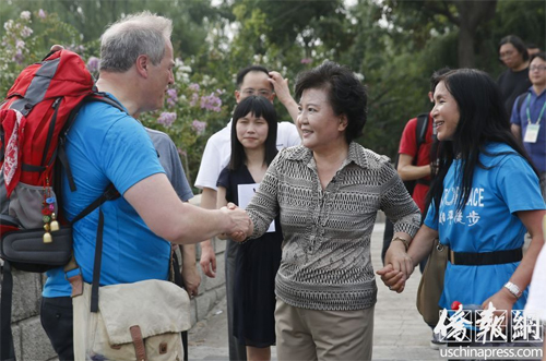 中国侨网7月27日，中国国务院侨办主任裘援平(中)在北京为开启徒步征程的英国麦克·贝茨勋爵(左一)，及其华裔夫人李雪琳(右一)送行。(美国侨报 王泽 摄)