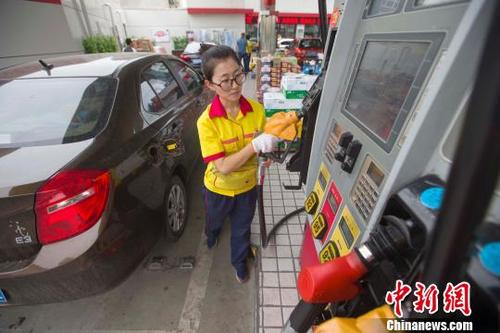 中国侨网山西太原，加油站工作人员正在给车辆加油。　张云 摄