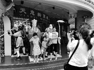 中国侨网天意市场闭市进入倒计时，顾客与门口的塑像合影。北京晨报记者 王巍/摄