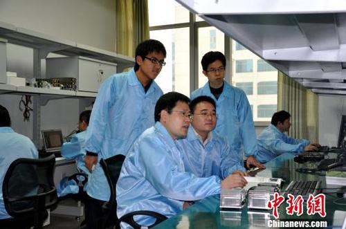 中国侨网图为，中国工程院院士、浪潮集团首席科学家王恩东（前排左一）与团队成员进行研发。资料图