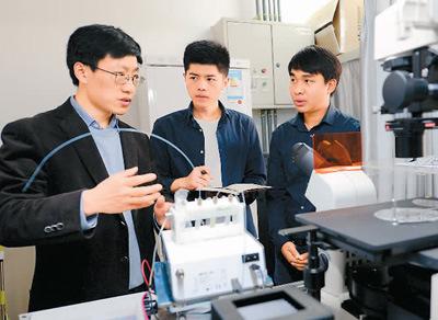 中国侨网2017年3月28日,泰国留学生卡纳特(右)和同学在西安交通大学机械工程学院教授韦学勇(左)指导下进行生物微流控芯片研究。 新华社记者 李一博摄