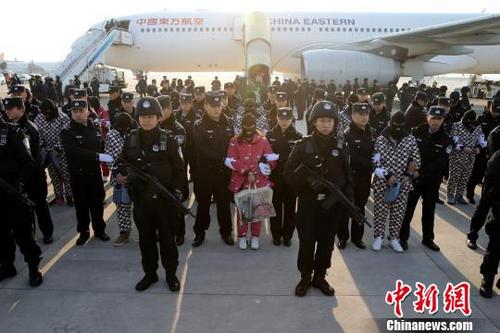 中国侨网图为嫌疑犯被押解下飞机。　张远　摄