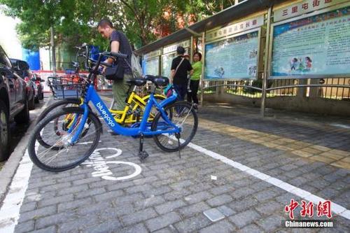 中国侨网图为一位外国友人正在北京三里屯地区的一处共享单车电子围栏内归还单车。 中新社记者 贾天勇 摄