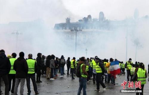 中国侨网当地时间12月1日，巴黎再次发生大规模示威活动。数以千计示威者聚集在凯旋门，凯旋门周边地区笼罩在催泪瓦斯的烟雾中。中新社记者 李洋 摄