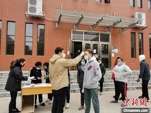 中国侨网湖南工业大学工作人员为留学生测量体温。　陈芹　摄