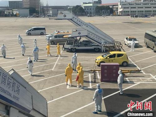 中国侨网温州龙湾机场内，工作人员身着防护服迎接航班落地。（资料图）　赵建斌　摄