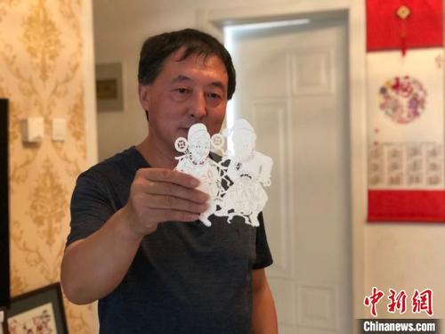 中国侨网李宝峰在展示剪纸作品。　郝烨　摄