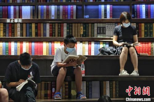 中国侨网三位读者在贵阳市观山湖区钟书阁书店内阅读书籍。　瞿宏伦　摄
