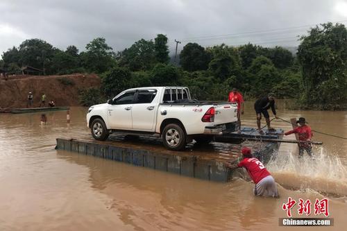 老挝南部水电站溃坝 水位上涨汽车乘木筏过河 