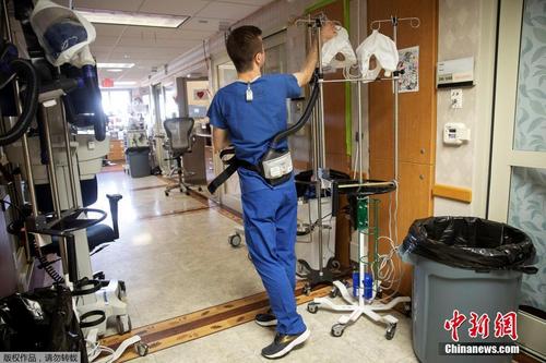 美国医护人员佩戴电动呼吸器进入新冠肺炎患者病房