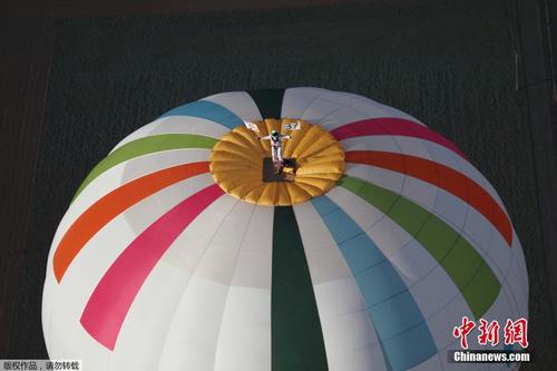 挑战“御球飞行” 男子站热气球顶冲击世界纪录