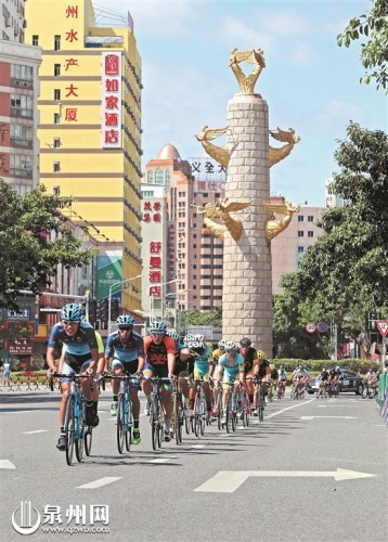 城市绕圈赛中，选手经过城雕。