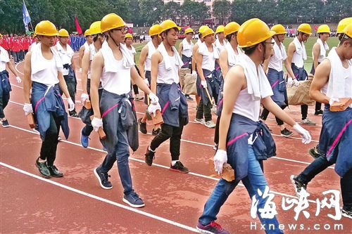 62名新生手持砖块、水泥袋、铲子等走方阵